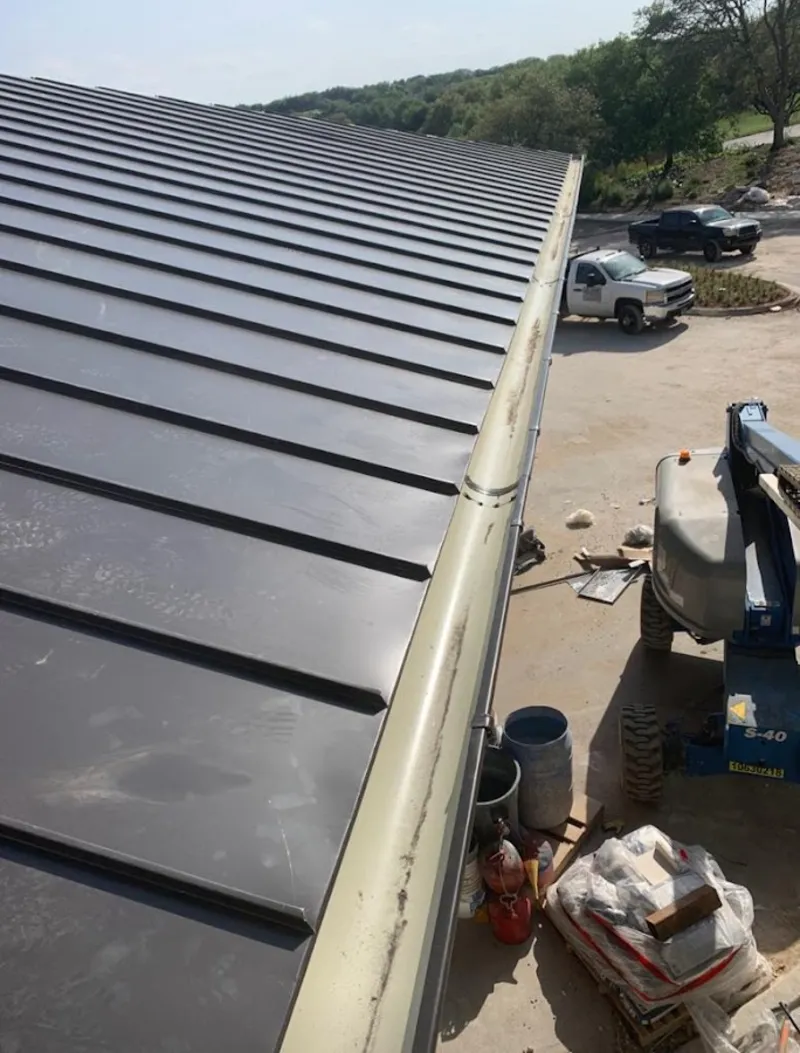 Standing seam panel and gutter detail on a metal roofing jobsite in Gonzales